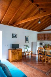 a living room with a blue couch and a kitchen at CR las Nuevitas Tranquilidad y Descanso in Hermigua