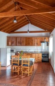 a kitchen with wooden cabinets and a table and chairs at CR las Nuevitas Tranquilidad y Descanso in Hermigua