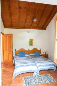 a bedroom with a large bed with blue pillows at CR las Nuevitas Tranquilidad y Descanso in Hermigua