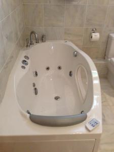 a white bath tub with a faucet in a bathroom at Room in Apartment - Luxury Apartment Lily Suite in Truro