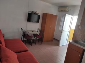 a living room with a red couch and a table with chairs at Apartmani Grozdanic Canj in Čanj