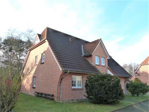 a red brick house with a black roof at Zum Leuchtturm - Ferienwohnung 3 in Sankt Peter-Ording