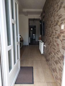 a hallway with a brick wall and an open door at Apartments Igor in Žabljak