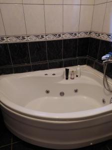 a white bath tub in a bathroom with a tile wall at Apartments Igor in Žabljak