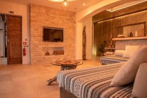 um quarto com uma cama e uma televisão numa parede de tijolos em Villa - Cantinho do Paraíso em Santo Espírito