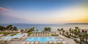 an aerial view of a resort with a pool and the ocean at Aminess Khalani Hotel in Makarska