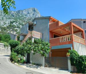 a house on a street with a mountain in the background at Studio Apartman Rea in Kotor
