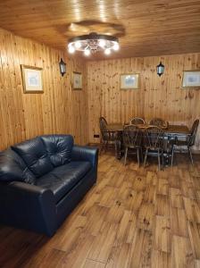 a living room with a leather couch and a table at Žilių sodyba in Plateliai