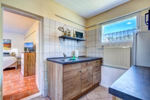 a kitchen with a sink and a window and a bed at Bungalow Jonas in Trassenheide