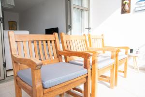 a group of wooden chairs sitting in a room at Entire Apartment in Tamarin Riviere Noire in Tamarin