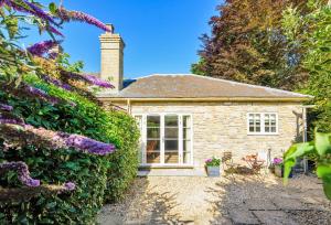 a stone cottage with a garden and purple flowers at La Rose in Gillingham
