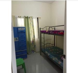 a room with two bunk beds and a blue dresser at Sunrise Enterprise in Tagum