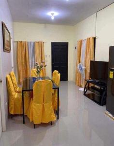 a living room with a table and yellow chairs at Sunrise Enterprise in Tagum