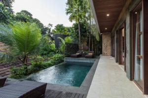 an infinity pool in the backyard of a house at Tirta Arum in Ubud