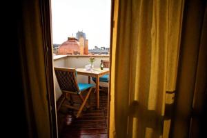 Zimmer mit einem Tisch, einem Stuhl und einem Fenster in der Unterkunft Rembrandt Hotel in Bukarest