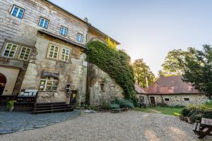 an old stone building with ivy growing on it at Hájovna hradu Houska in Doksy