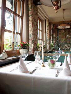 a table with a white table cloth and wine glasses at Landhotel Sangermann in Oberveischede