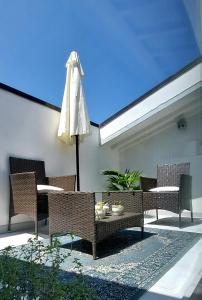une terrasse avec des chaises, une table et un parasol dans l'établissement Castle Rooms, à Prato