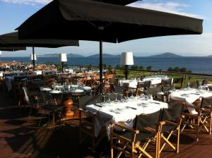 um restaurante com mesas e cadeiras e um guarda-sol em Hotel Suadiye em Istambul