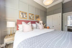 1 dormitorio con 1 cama blanca grande con almohadas blancas en No1 Apartments Edinburgh - George IV Bridge, en Edimburgo