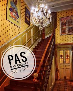 eine Treppe in einem Gebäude mit einem Kronleuchter und einem Passzeichen in der Unterkunft Hôtel de l'Abeille in Orléans