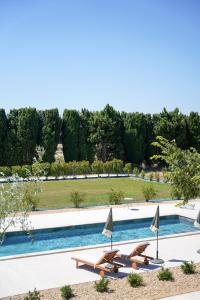 una piscina con 2 mesas y 2 sillas al lado en La maison en Provence, en Graveson