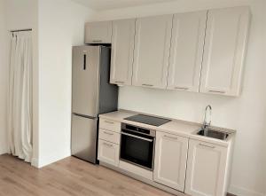 a kitchen with white cabinets and a refrigerator at Castle Rooms in Prato