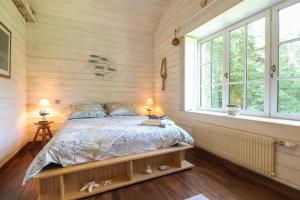 ein Schlafzimmer mit einem Bett in einem Zimmer mit Fenstern in der Unterkunft Manderley in Arceau