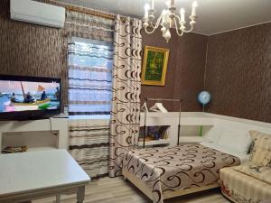 ノヴォロシースクにあるBurun - Бурунのベッド、テレビ、ソファが備わる客室です。