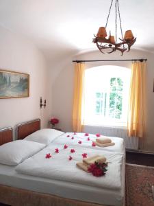 a bedroom with a bed with red flowers on it at Hájovna hradu Houska in Doksy