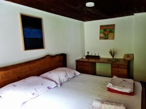 a bedroom with a large white bed and a desk at LINCA Hiška pod slapom in Podvelka