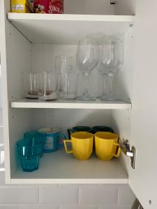 a cupboard filled with glasses and other kitchen utensils at Hygge apartment Narva in Narva +5 photos