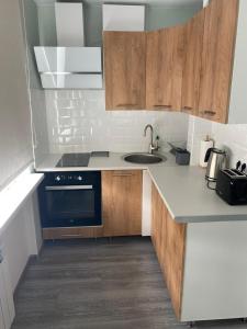 a kitchen with wooden cabinets and a blue oven at Hygge apartment Narva in Narva