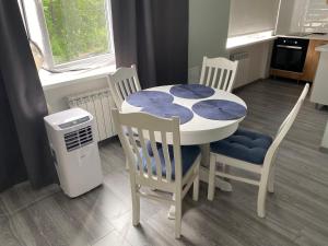 a kitchen with a table and four chairs and a small table and chairsktop at Hygge apartment Narva in Narva