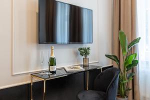 Habitación con mesa, botella de champán y TV. en AR Apartamenty, en Poznan