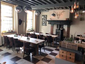 un ristorante con tavoli, sedie e un camino di Het Heerenlogement Beusichem a Beusichem