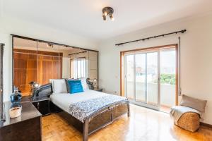 a bedroom with a bed and a large window at Vila do Conde Sea House in Vila do Conde