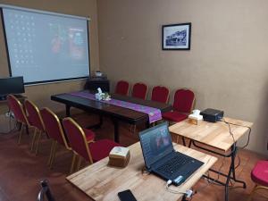 a conference room with a laptop on a table and chairs at Roemah 28 Syariah in Medan