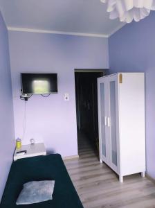 a room with a bed and a tv on the wall at Agroturystyka "U Źródła" in Milicz