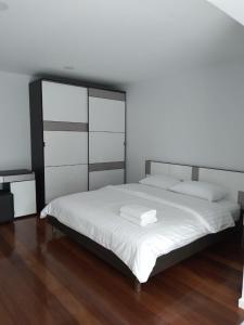 een slaapkamer met een groot bed met witte lakens bij Cha-am Beach Vacation Home in Cha Am