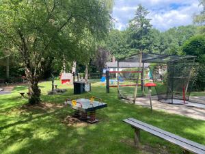 un parque con parque infantil y un banco en el césped en Ruim privacyvol chalet met overdekt terras, en Ermelo