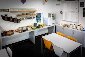 a kitchen with a counter with a table and chairs at Hostel Pekarna in Maribor