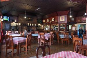 a dining room with tables and chairs in a restaurant at Dullstroom Inn in Dullstroom