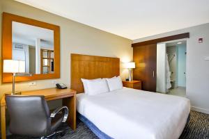 a hotel room with a bed and a desk and a chair at Hyatt House Naperville/Warrenville in Warrenville