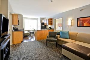 a living room with a couch and a room with a kitchen at Hyatt House Naperville/Warrenville in Warrenville
