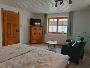 een slaapkamer met een bed, een bank en een tv bij Charlys Ferienhaus (ALTSTADT VOLKACH) in Volkach