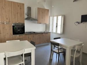 a kitchen with a white table and chairs and a kitchen with a stove at Le zagare in Palagiano