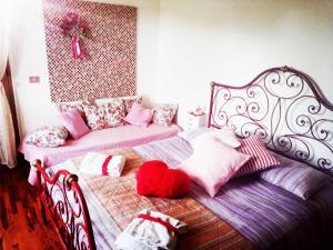 a bedroom with two beds with pillows on them at La Vie En Rose in Buia