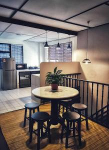 - une cuisine avec une table et des tabourets dans une pièce dans l'établissement Treehouse Hostel, à Kuching