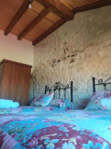 1 dormitorio con 1 cama en una pared de piedra en Casa Marite Vivienda de uso turístico en Campillo de Aranda
